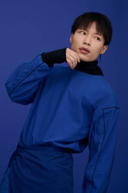 Çekici bir Asyalı genç adam, etkileyici yüzü ve şık kıyafetiyle kendine güveni yayar..