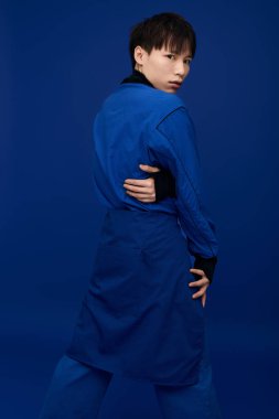 Mavili şık genç Asyalı adam çekici görünüşüyle özgüven ve karizma yayıyor..