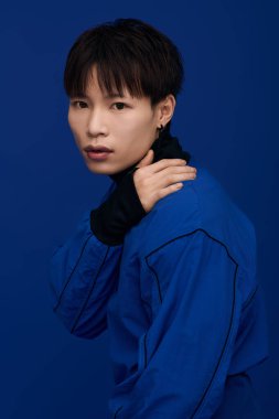 Kendine güvenen Asyalı genç adam modern bir ortamda tarz ve karizma sergiliyor..