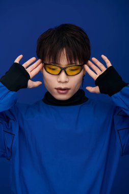 Genç adam güneş gözlükleriyle kendine has bir moda anlayışı sergiliyor..