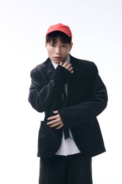 Karizmatik Asyalı genç adam moda anlayışını gün ışığı altında şık bir şehir zemininde sergiliyor..