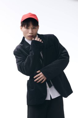 Şık, genç Asyalı adam modaya uygun bir kıyafetle rahatça poz veriyor..