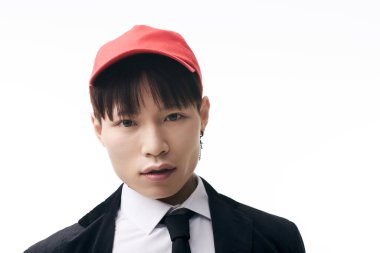 Yakışıklı Asyalı genç erkek modeller minimalist bir arkaplan karşısında kırmızı şapkalı şık bir görünüm sergiliyorlar..