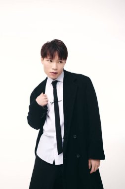 Şık Asyalı genç adam kendine güvenerek poz veriyor. Yetenekli ve çarpıcı bir ifade sergiliyor..