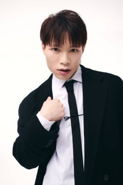 Genç ve yakışıklı bir adam, kendine güvenen, çekici ve zarif bir şekilde poz verir..