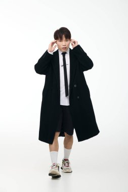 Genç, şık bir adam, minimalist bir geçmişe karşı güvenle etkileşime geçer..