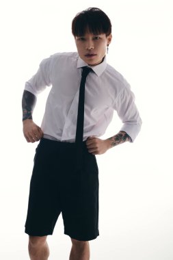 Çekici genç adam, kendine güvenen duruşu ve çarpıcı tavrıyla modern moda sergiliyor..