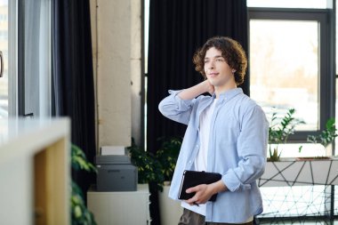 Modern ofiste genç profesyonel pozisyonlar, gelecekteki hedefler ve hedefler hakkında düşüncelere dalmış..