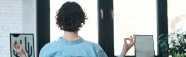 Yakışıklı genç bir profesyonel sakince bir ofiste oturur, farkındalık ve meditasyon pratiği yapar..