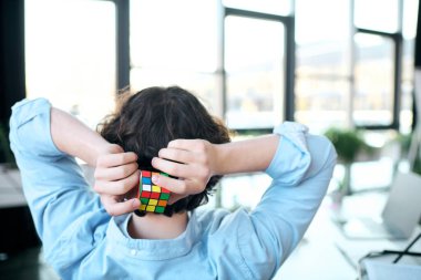 Çarpıcı özellikleri olan genç bir adamın iş yerinde Rubiks küpünü çözmesi biraz zaman alır..
