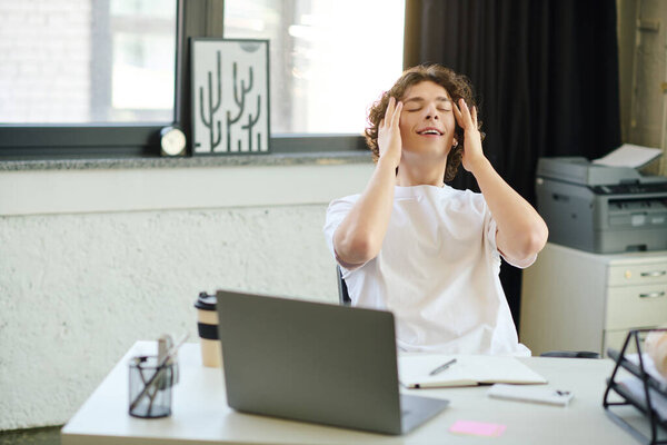 Young professional feels overwhelmed in a bright and stylish workspace during a busy workday.
