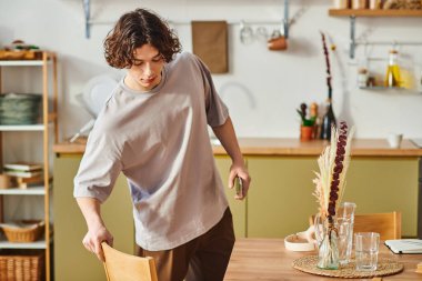 Genç bir adam modern ve davetkar çalışma alanını özenle düzenler..