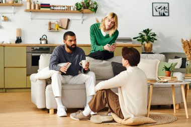 Eller kahve fincanlarında ve telefonlarda, genç erkekler şık ve rahat bir ev ortamında kitaplarla kaynaşıyor..