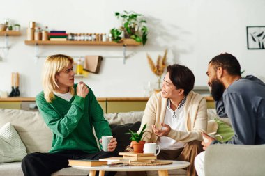 Evdeki samimi okuma kulübü toplantısında üç genç adam fikir ve kahkaha paylaşıyor..