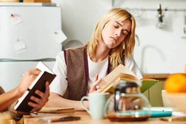 Genç erkekler rahat bir ortamda kitap okurken düşünceli tartışmalara girişirler..