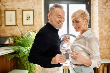 Orta yaşlı bir çift sıcak bir atmosferde birbirlerine eşlik ederek kahkaha ve içkileri paylaşır..