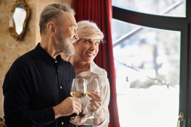 Sıcak bir yerde kahkaha ve içkileri paylaşan olgun bir çift birlikte eğleniyor..