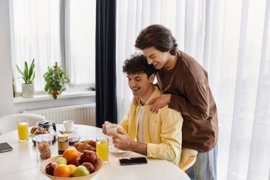 Eşcinsel çift, kahvaltı ve güneş ışığıyla çevrili keyifli bir sabahı paylaşıyor..