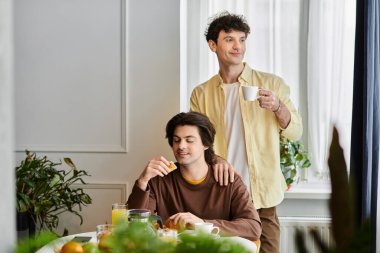 Eşcinsel çift, keyifli bir kahvaltı yapıyorlar. Aşklarını ve kahkahalarını lüks evlerinde paylaşıyorlar..