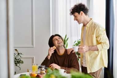 İki yakışıklı adam, şık dairelerinde gülümsemeyle dolu keyifli bir sabahı paylaşıyor..