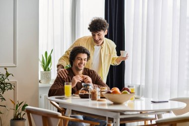 Eşcinsel çift kahvaltıdan zevk alır, ışık dolu şık evlerinde gülücüklerini paylaşırlar..