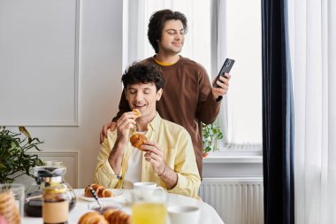 Eşcinsel çift, şık bir dairede pastalarla neşeli bir sabahı paylaşıyor..