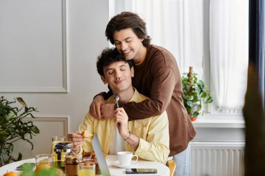 Sıcak ve davetkar bir atmosferle çevrili iki adam tatlı bir kahvaltıyı paylaşıyor..