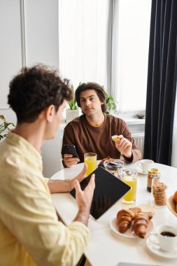 İki adam, kahkaha ve şefkat dolu şık bir dairede brunch 'tan hoşlanırlar..