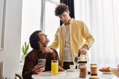Sevgi dolu bir eşcinsel çift, günışığıyla dolu modern dairelerinde rahat bir kahvaltı yapar..