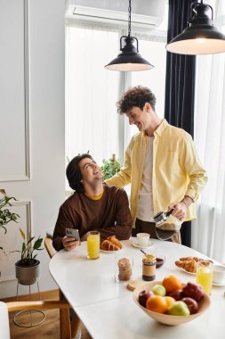 Eşcinsel bir çift şık evlerinde samimi bir kahvaltı, gülümseme ve şefkat paylaşıyor..