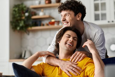 İki güler yüzlü eşcinsel çift şık bir dairede kucaklaşır, birlikte hassas ve mutlu bir anı paylaşırlar..