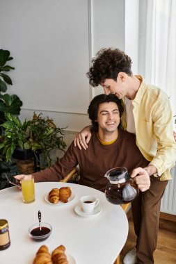 İki yakışıklı adam bitkilerle dolu şık bir dairede kahvaltıdan zevk alıyor..