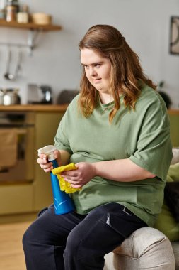 Down sendromlu güzel bir kadın evde rahatlıyor, kendine güvenerek temizliğe odaklanıyor..