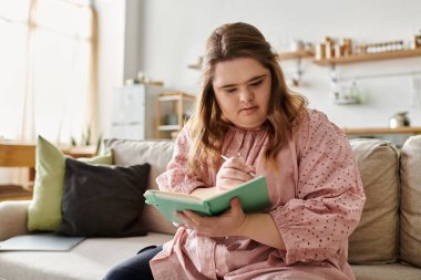 Güzel genç bir kadın evinde rahat bir köşede yazmayı seviyor. Kendine güven ve neşe saçıyor..