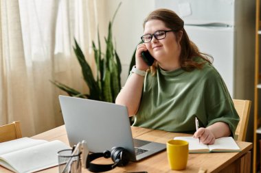 Rahat bir ev ortamında, Down sendromlu genç bir kadın not alırken bir telefon görüşmesi yapmaktan hoşlanır..
