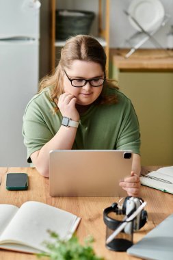 Rahat bir evde Down sendromlu genç bir kadın neşeyle tabletle meşgul oluyor..