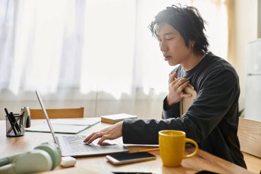 Genç bir Asyalı öğrenci rahat ev ortamından online öğrenim görüyor..
