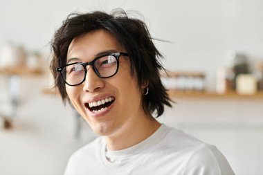 Gözlüklü neşeli bir genç adam evinde dekorasyonla çevrili neşeli bir anın tadını çıkarıyor..