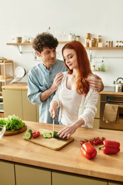 Genç bir çift, sıcak mutfaklarında birlikte yemek pişirip gülmekten zevk alır..