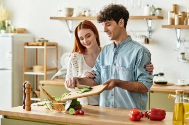 Çift, davetkar mutfaklarında birlikte yemek hazırlar..
