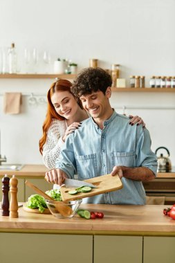 Sevgi dolu bir çift, birlikte yemek pişirirken ve kahkahalarla doluyken mutfaklarında keyifli anlar paylaşır..