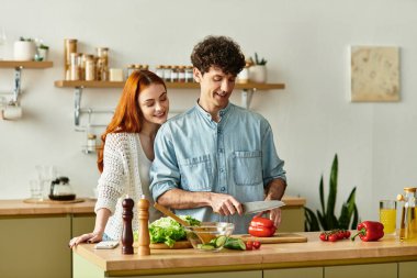 Genç bir çift, davetkar mutfaklarında, sevgi ve birlikteliği kucaklayan bir yemek hazırlıyor..