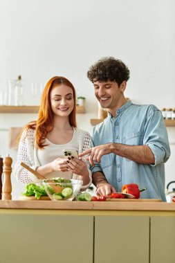 Genç çift, sıcak ev ortamlarında birlikte yemek hazırlarken gülümseyerek kaliteli vakit geçirmeyi sever..