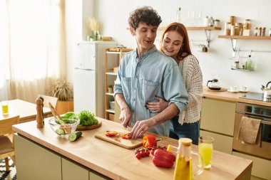 Sevgi dolu bir çift neşeli bir anı paylaşır, sıcak ev ortamlarında birlikte yemek pişirir ve gülerler..