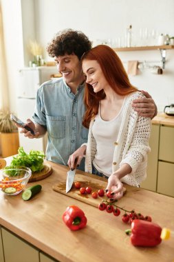 Genç bir çift birlikte yemek pişirir, sıcak evlerinde neşeli anılar yaratırlar..