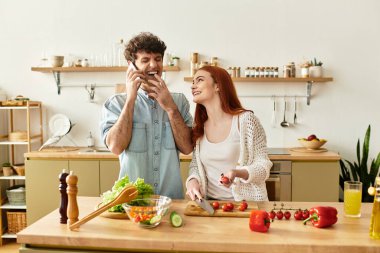 Sevgi dolu çift, mutfaklarında birlikte yemek hazırlarken neşe ve kahkahayı paylaşır..