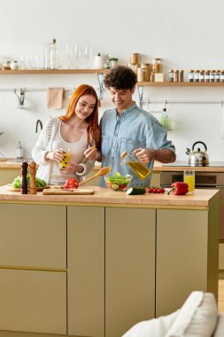 Sevgi dolu çiftler şık mutfaklarında kaliteli vakit geçirmeyi severler, gülümseyerek lezzetli yemekler hazırlarlar..