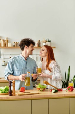 Mutlu bir çift, şık mutfaklarında birlikte yemek hazırlarken kahkaha ve aşkı paylaşır..