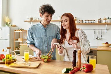Parlak ve modern bir mutfakta, bir çift neşeyle yemek hazırlar, gülümseme ve şefkat paylaşırlar..
