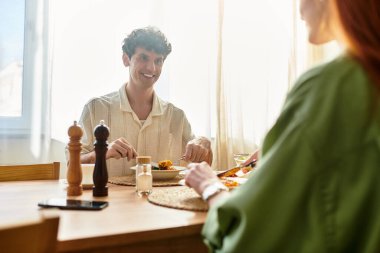 Genç çift evde romantik bir akşam yemeği yiyor, kahkahalar ve sıcak sohbetlerle dolu..